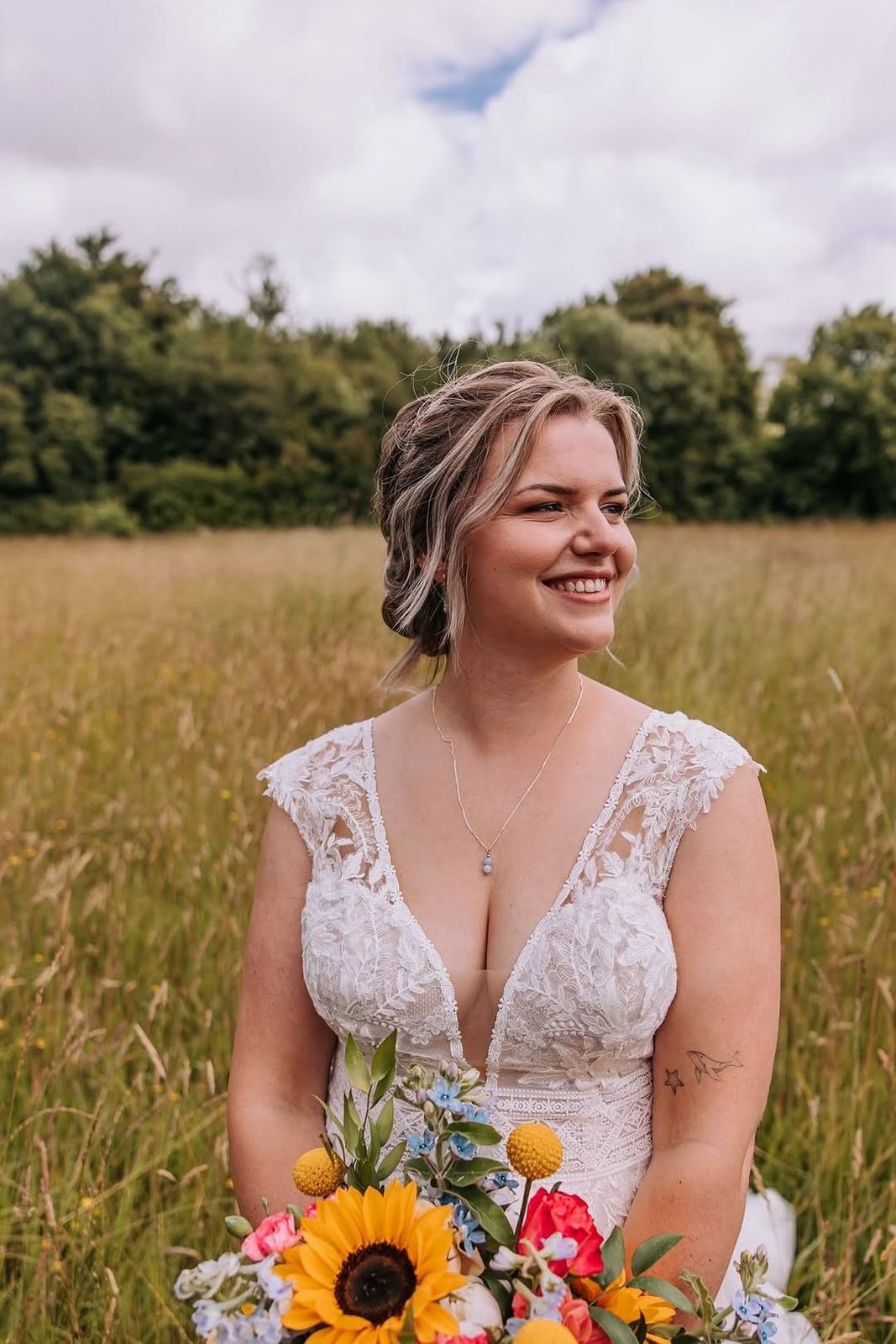 Stralende bruid met een boeket van zonnebloemen in een veld