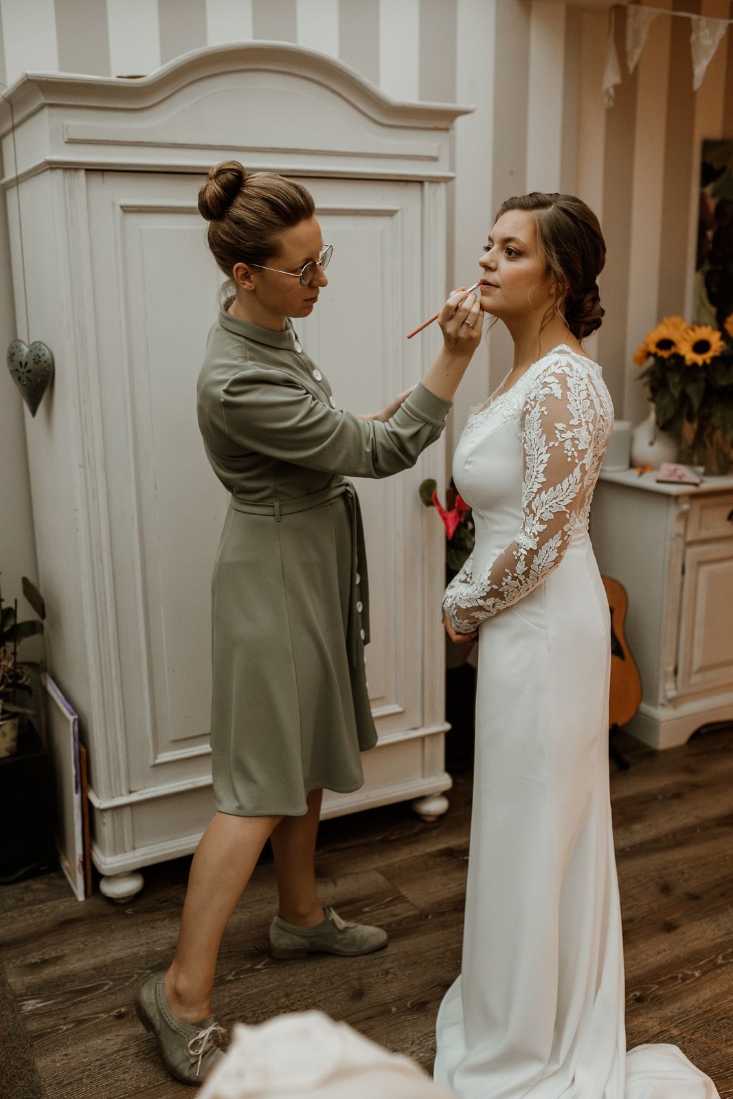 Johanna werkt de lippen van een bruid bij, in een slaapkamer met zonnebloemen