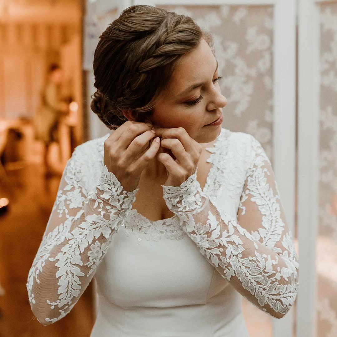 Bruid met een gedraaide knot doet haar oorbellen in